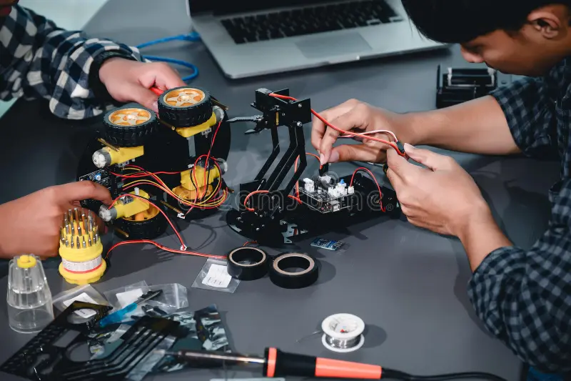 Asian students assembling robotics kits